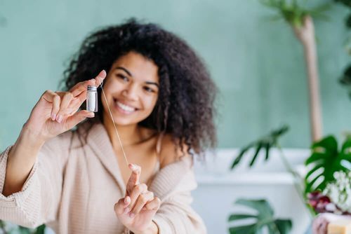 woman measuring out dental floss