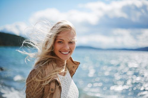 young woman smiling at the ocean